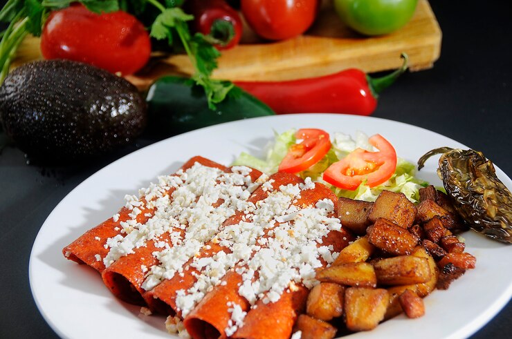Enchiladas rojas de comida típica mexicana con ensalada de papas y chiles