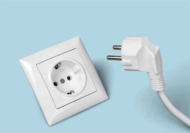Enchufe eléctrico blanco en la toma de corriente en una pared.