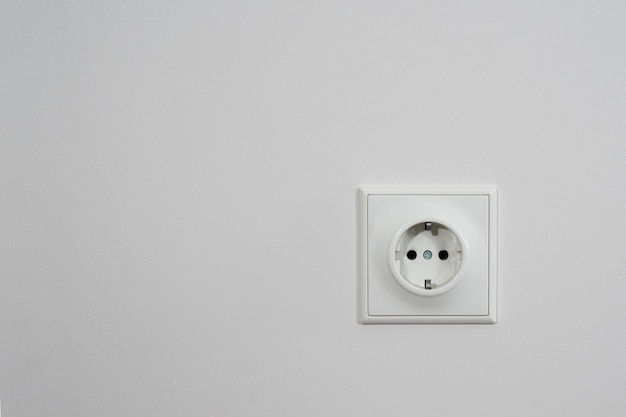 El enchufe eléctrico en una pared blanca