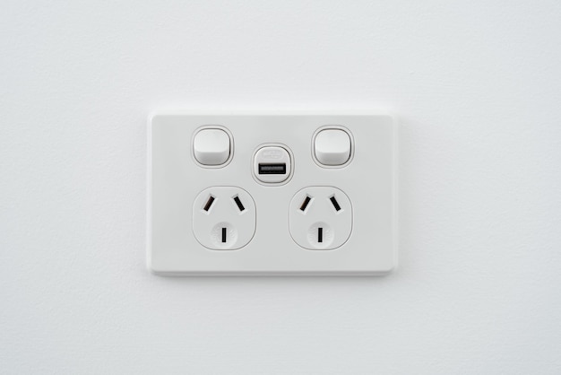 Enchufe con interfaz usb e interruptor en pared blanca