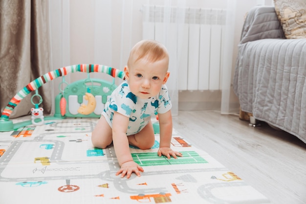 Encima de la foto en ángulo de un adorable bebé acostado en un piso apto para niños, alfombras de rompecabezas mirando hacia arriba