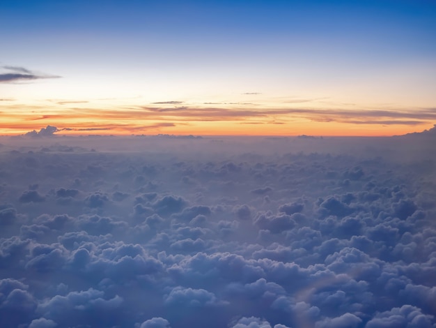 Por encima de las nubes, el cielo crepuscular en un alto nivel de actitud desde el avión, nubes esponjosas como el cielo