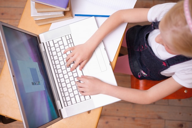 Por encima de la vista de una niña usando un cuaderno