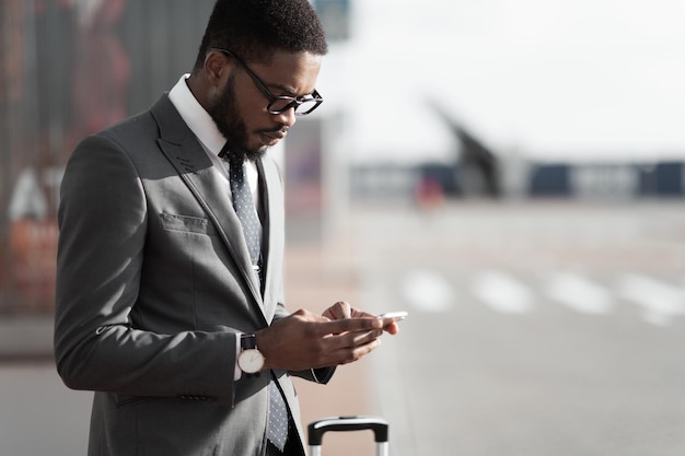 Encomendar táxi afro empresário usando o aplicativo de telefone móvel