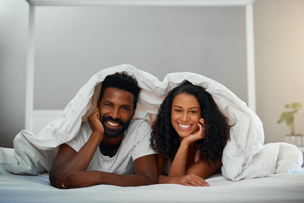 Encontrando conforto um no outro Foto recortada de um jovem casal atraente na cama em casa