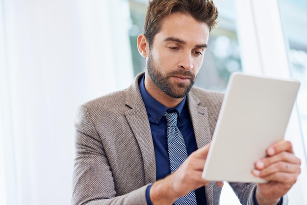 Encontrando uma nova maneira de acompanhar as reuniões Foto de um empresário usando seu tablet digital