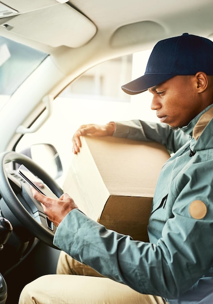 Foto encontrar la ruta más rápida para su próxima entrega captura de un mensajero usando un teléfono celular mientras está sentado en una camioneta de reparto