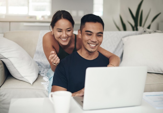 Encontraron algo interesante en línea Foto de una pareja joven usando una computadora portátil juntos en casa