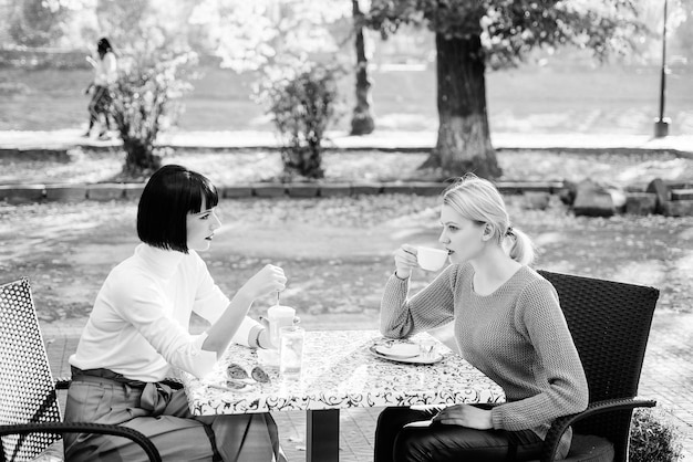 Encontro de amizade União e amizade feminina Amizade verdadeira amizade amigáveis relações íntimas Confie nela Amigas bebem café e gostam de conversar Conversa de duas mulheres terraço do café