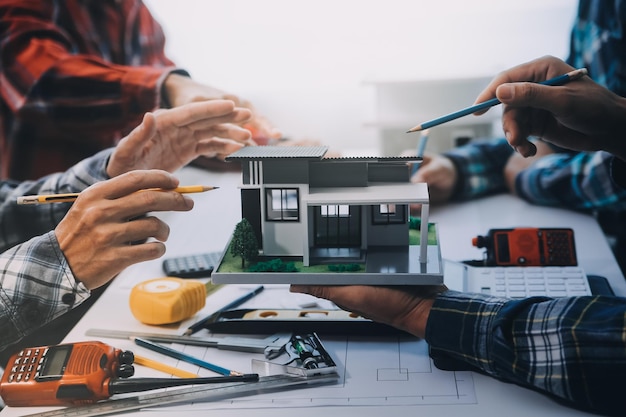 Encontro de engenheiros trabalhando e apontando para desenhos no escritório para discutir ferramentas de engenharia e conceito de construção