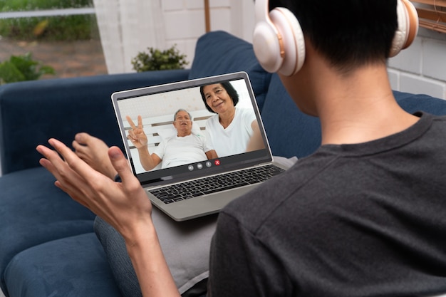 Encontro de videoconferência de homem asiático com pai idoso doente para encorajar e perguntar sobre doenças. Conceito de tecnologia de comunicação,