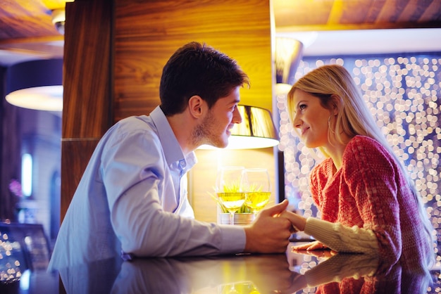 encontro romântico à noite no restaurante feliz casal jovem com copo de vinho, chá e bolo