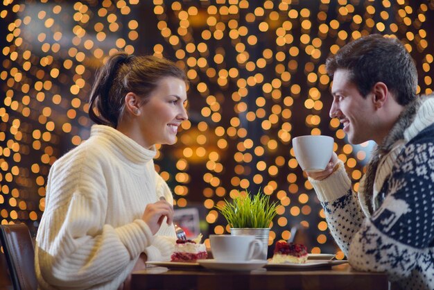 encontro romântico à noite no restaurante feliz casal jovem com copo de vinho, chá e bolo