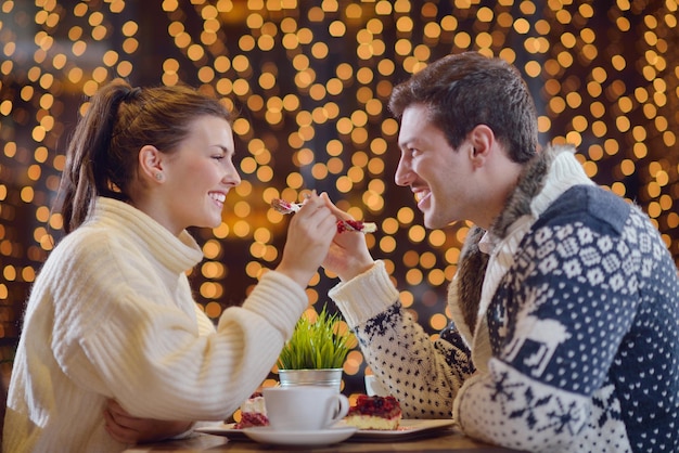 encontro romântico à noite no restaurante feliz casal jovem com copo de vinho, chá e bolo