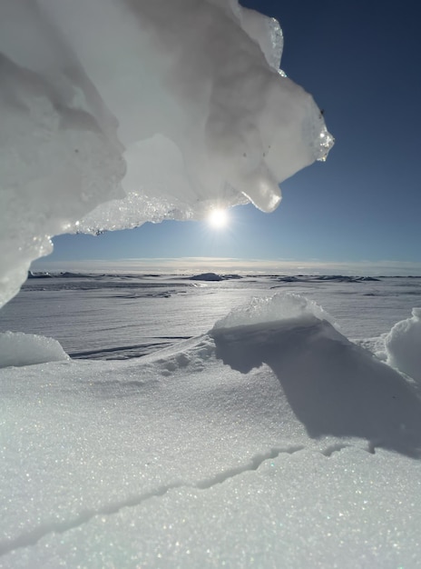 Encostas de gelo em dia ensolarado de inverno, gelo transparente de cor azul, céu puramente azul, longas sombras, um solo virgem puro coberto de neve, barkhans de neve, . Foto de alta qualidade