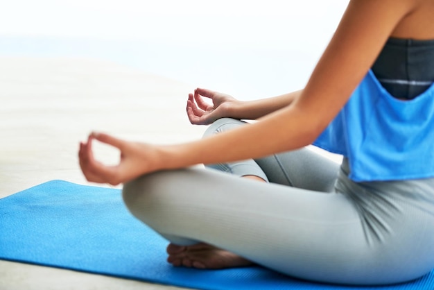 Encuentra tu zen en cualquier situación Captura recortada de una mujer joven practicando la postura del loto