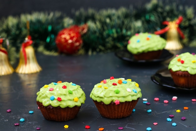 Se encuentran cupcakes caseros cubiertos con decoraciones de crema y pastelería