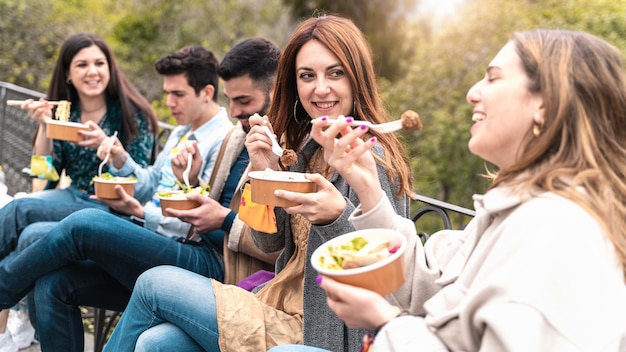 Foto encuentro de jóvenes comiendo comida orgánica para llevar en tazones sin plástico