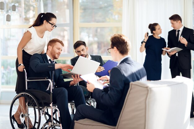 Encuentro de personas con discapacidad en sala luminosa con amplios ventanales.