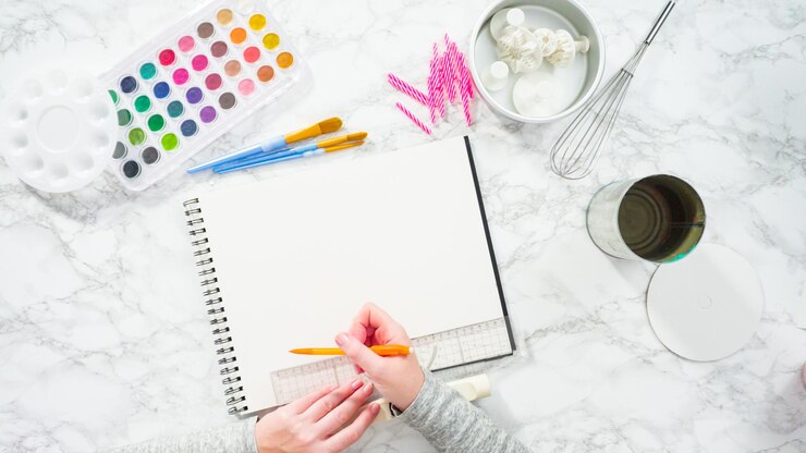 Foto endecha plana. baker está dibujando el diseño de un pastel de cumpleaños.