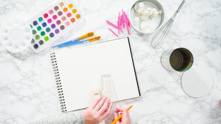 Foto endecha plana. baker está dibujando el diseño de un pastel de cumpleaños.