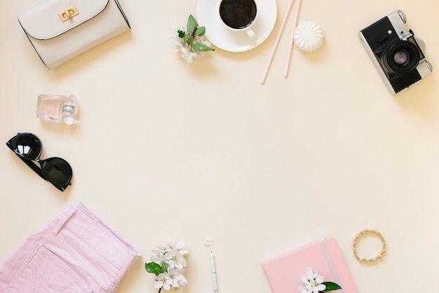 Endecha plana de una bloguera viajera que planifica la bolsa de la cámara de la tableta taza de té sobre fondo beige con espacio de copia