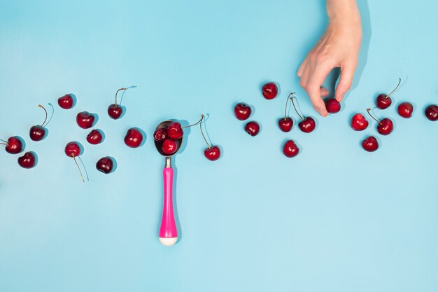 Endecha plana con cerezas orgánicas frescas en una cuchara de helado