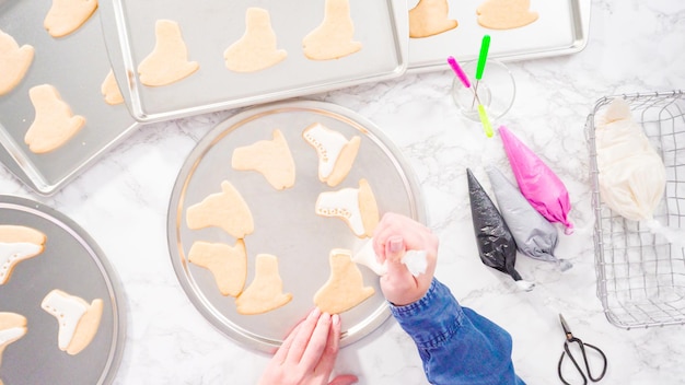 Endecha plana. Decoración de galletas de azúcar en forma de patines de hielo con glaseado real de color blanco.