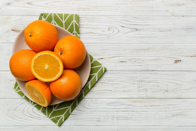 Endecha plana de fruta naranja fresca con rodajas en plato sobre fondo de color Vista superior con espacio de copia