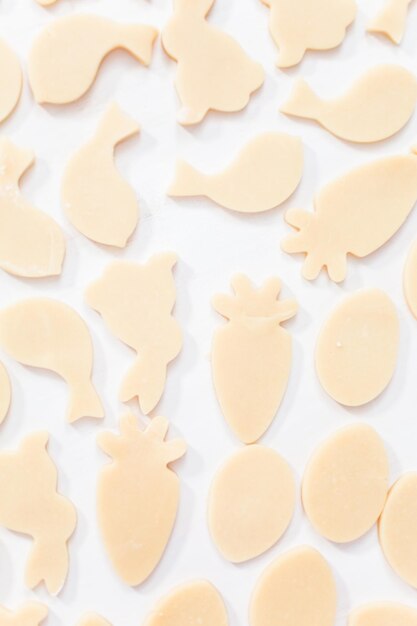 Endecha plana. Galletas de azúcar de Pascua sin hornear sobre una mesa blanca.