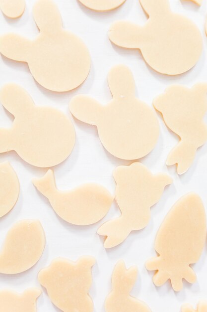 Endecha plana. Galletas de azúcar de Pascua sin hornear sobre una mesa blanca.