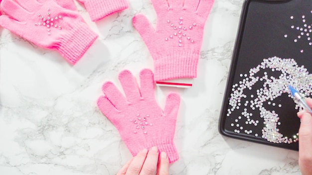 Endecha plana. Guantes de niños rosa strass con formas de copos de nieve.