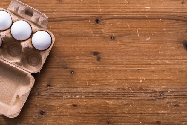 Endecha plana. Huevos orgánicos blancos sobre la mesa para hacer pan jalá.