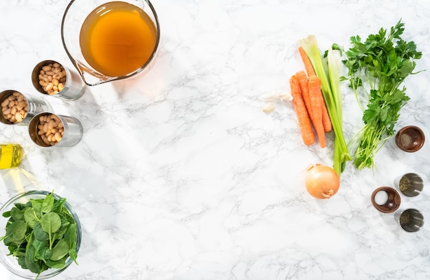 Endecha plana. Ingredientes para cocinar sopa vegetariana de frijoles blancos.