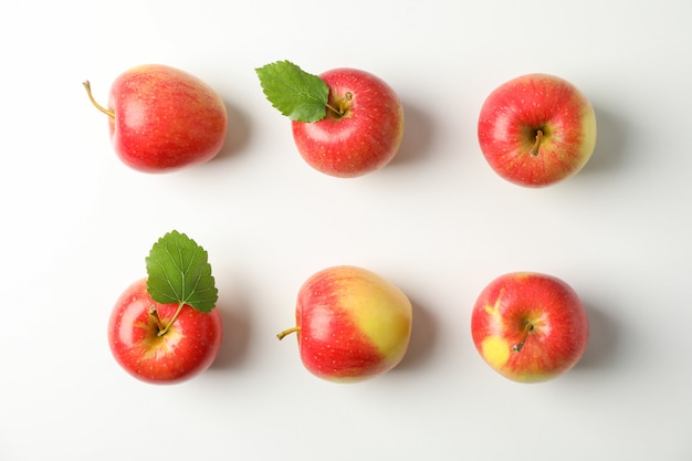 Endecha plana con manzanas rojas en mesa blanca