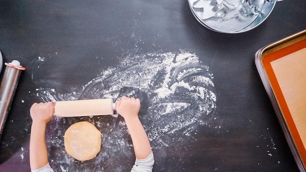 Endecha plana. Niña horneando galletas de calaveras de azúcar para la festividad del Día de los Muertos.