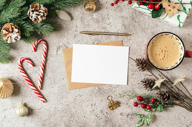 Endecha plana de papel en blanco maqueta para tarjeta de felicitación de navidad fondo gris con taza de café abeto