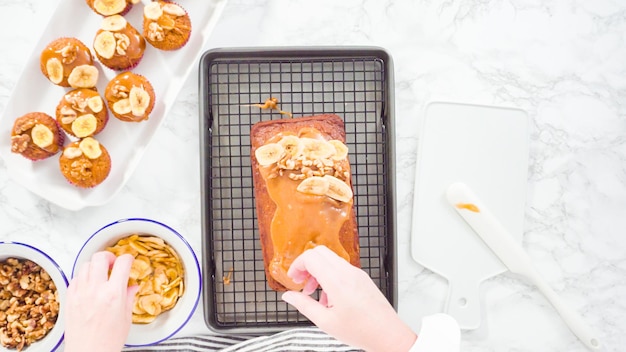 Endecha plana. Paso a paso. Adorne la hogaza de pan de plátano con caramelo casero, chips de plátano y nueces.