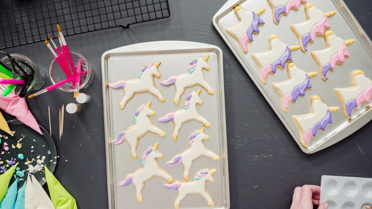 Foto endecha plana. paso a paso. decorar galletas de azúcar de unicornio con glaseado real.