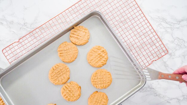 Endecha plana. Paso a paso. Galletas de mantequilla de maní recién horneadas en una bandeja para hornear.