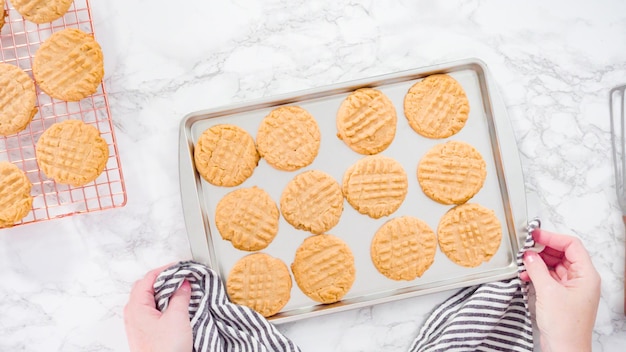 Endecha plana. Paso a paso. Galletas de mantequilla de maní recién horneadas en una bandeja para hornear.