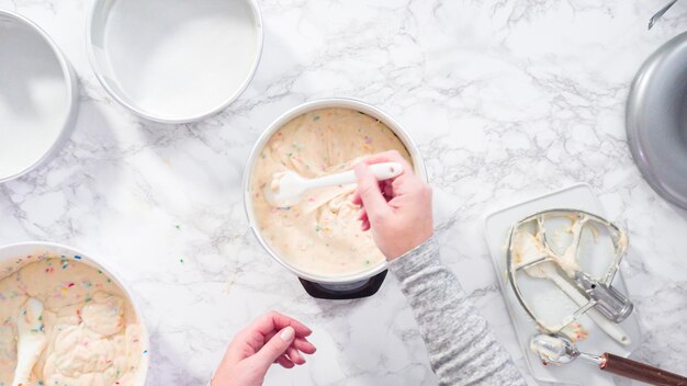 Endecha plana. Paso a paso. Medición de masa de pastel funfetti en una báscula de cocina digital.