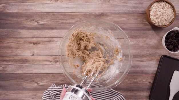 Endecha plana. Paso a paso. Mezcla de ingredientes para hornear galletas de avena en un tazón de vidrio.