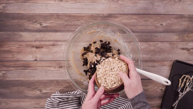 Endecha plana. Paso a paso. Mezcla de ingredientes para hornear galletas de avena en un tazón de vidrio.