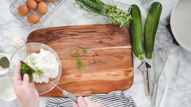 Endecha plana. Paso a paso. Mezclar los ingredientes en un tazón para hacer pasteles de calabacín.