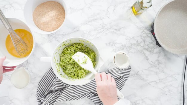 Endecha plana. Paso a paso. Mezclar los ingredientes en un tazón para hacer pasteles de calabacín.