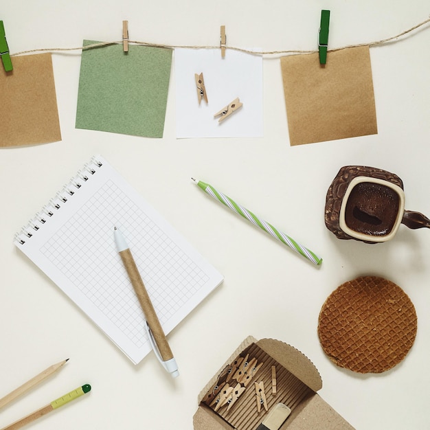 Endecha plana de pegatinas de papel kraft con pinzas para la ropa, café y papelería