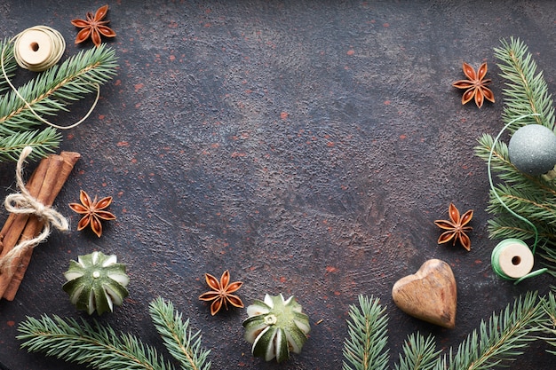 Endecha plana con ramas de abeto y adornos navideños sobre fondo oscuro