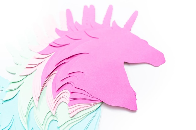 Endecha plana. Recortes de papel de unicornio de colores sobre un fondo blanco.