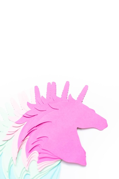 Endecha plana. Recortes de papel de unicornio de colores sobre un fondo blanco.